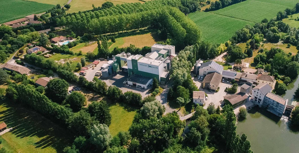 Vue aérienne du site du moulin Marion, entouré de champs, d'arbres et d'une rivière